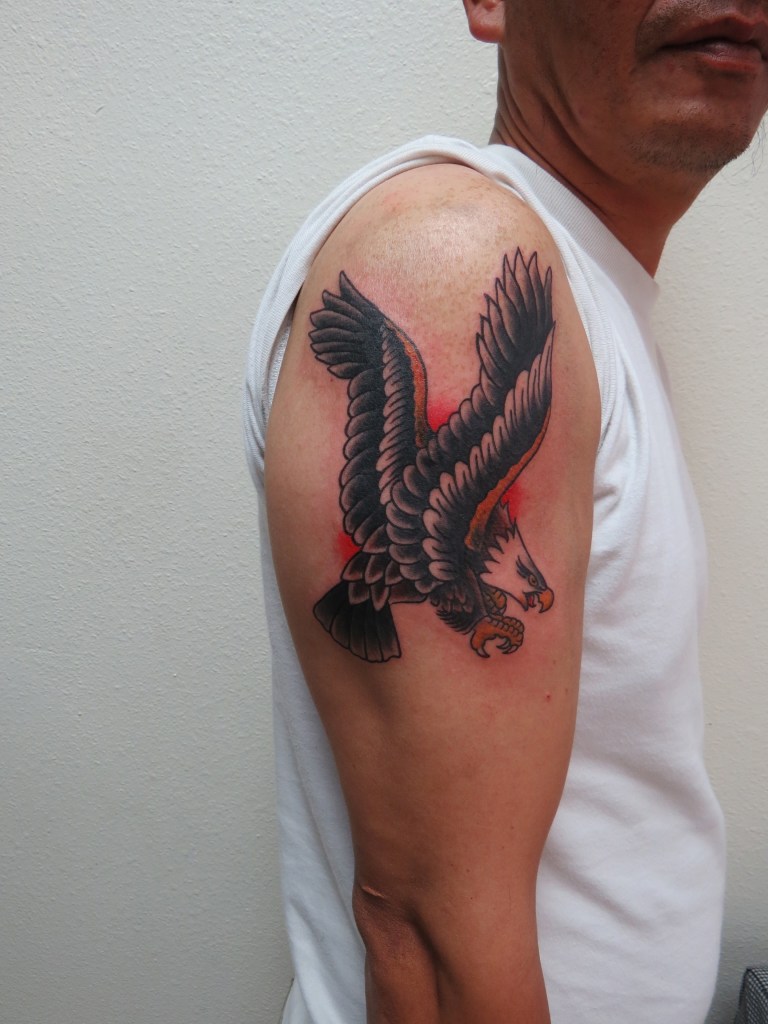 Decorative image to show artists tattoo work. Photograph of a freshly done tattoo on a bicep. Tattoo is of an eagle with its wings raised 